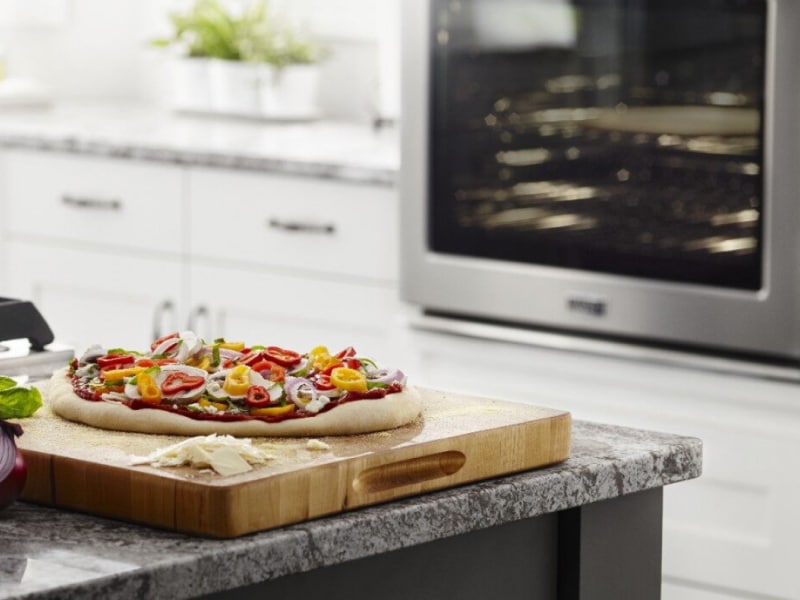 Homemade pizza on a wooden cutting board