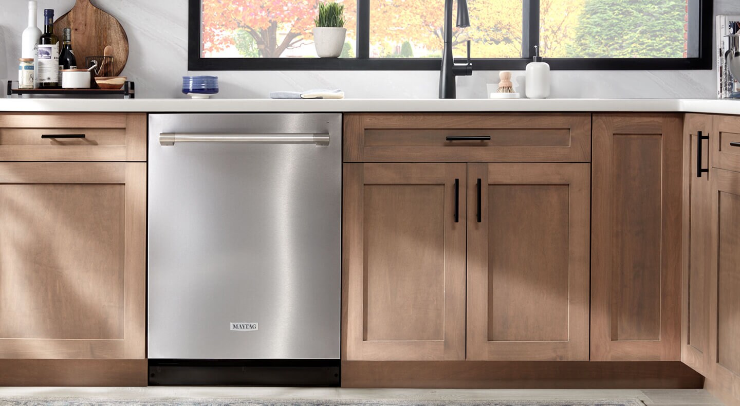 A Maytag® dishwasher in a kitchen with brown cabinets