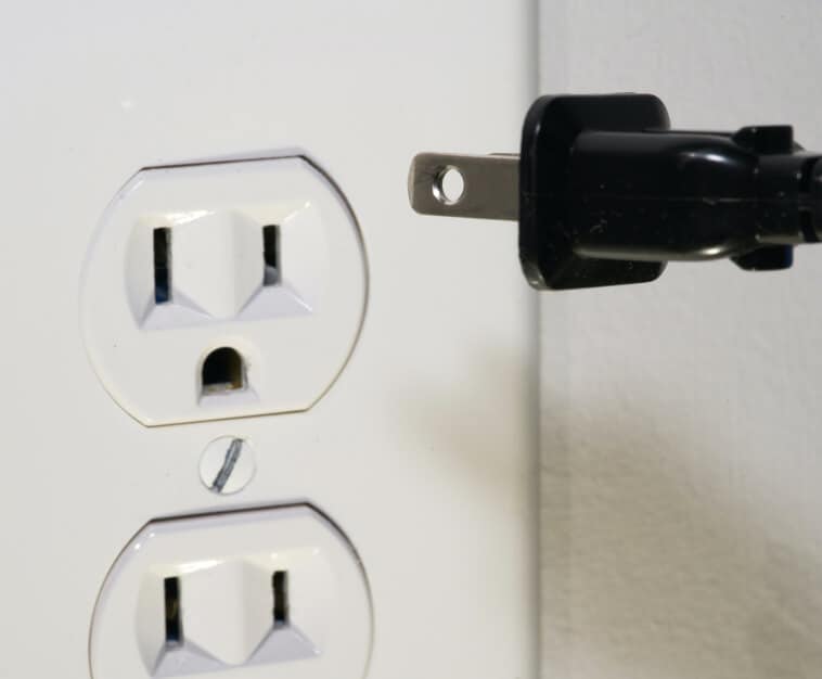 Power cord being unplugged from electrical outlet