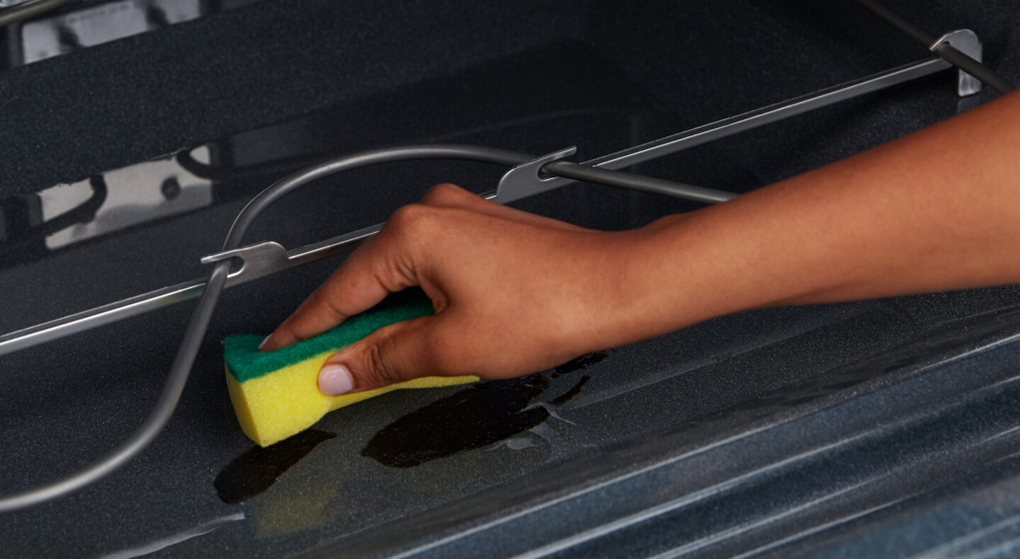 Person using a sponge to clean inside of oven Person using a sponge to clean inside of oven