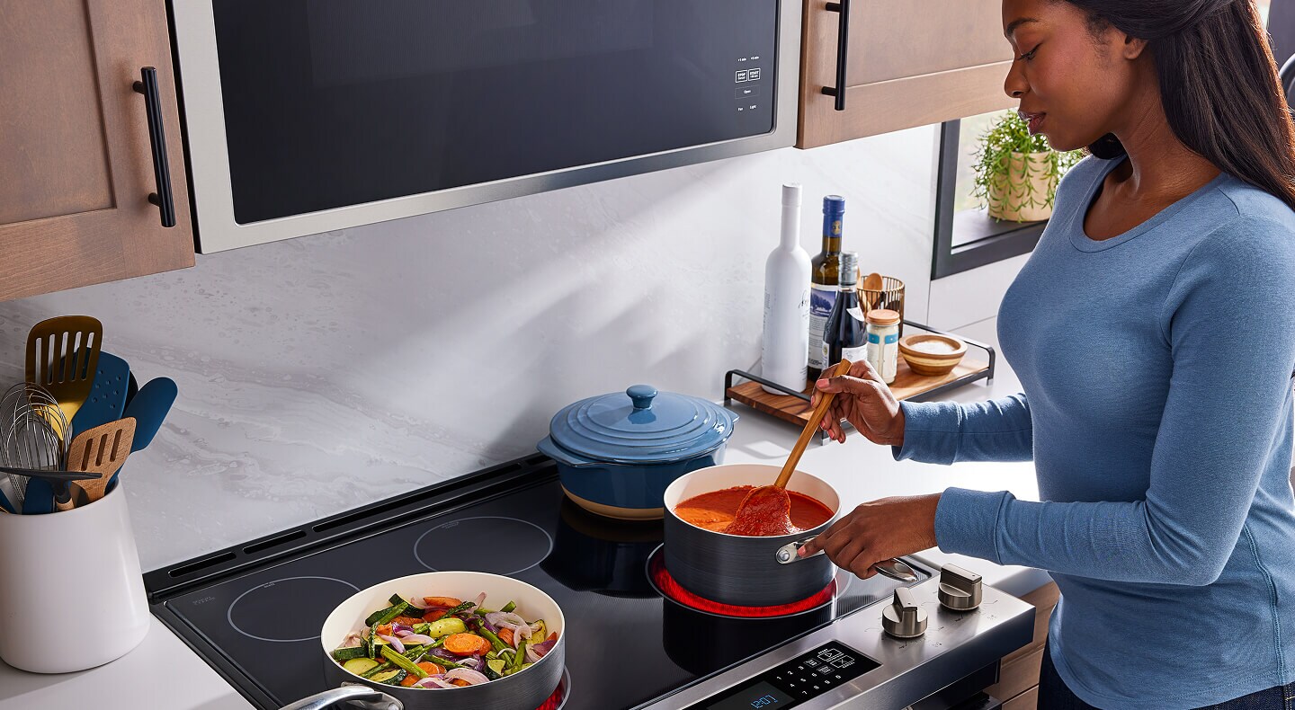 Person cooking food on a Maytag® electric range