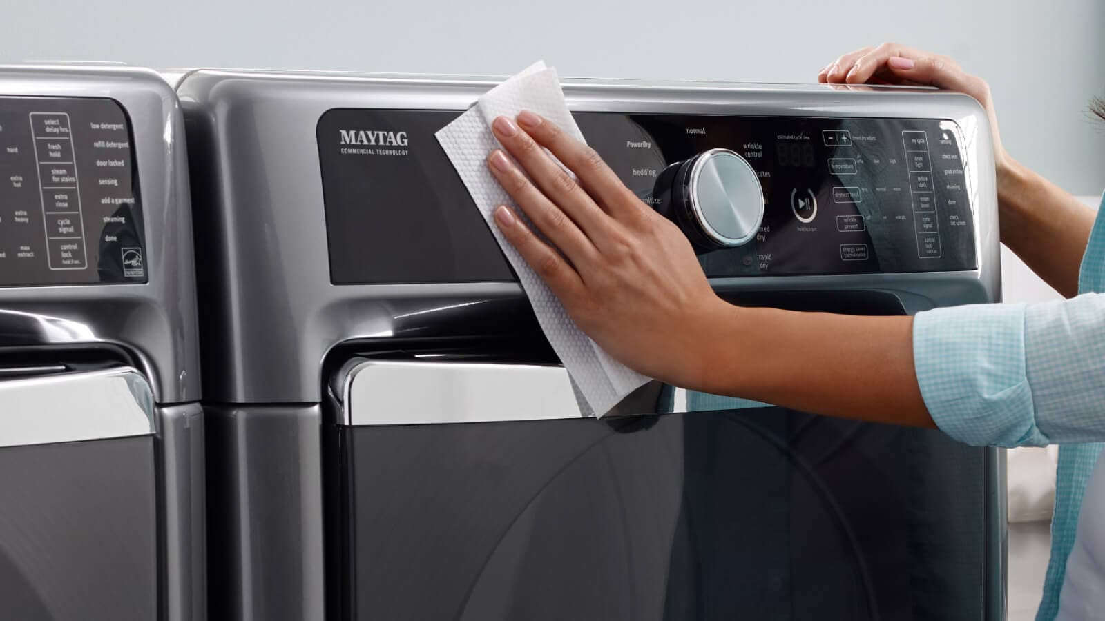 Person wiping outside of washing machine