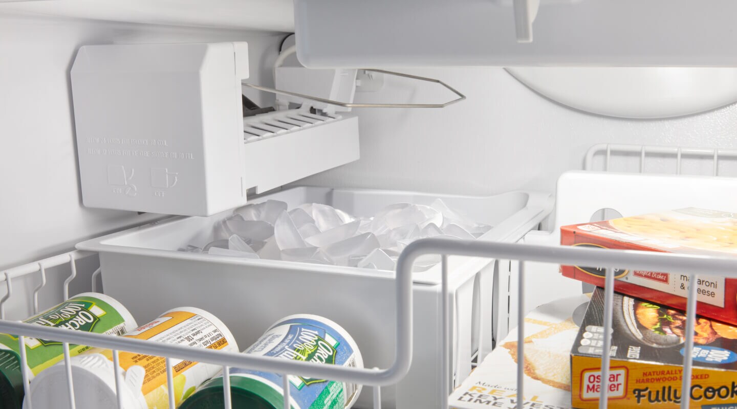 An internal ice cube container inside of a bottom mount refrigerator