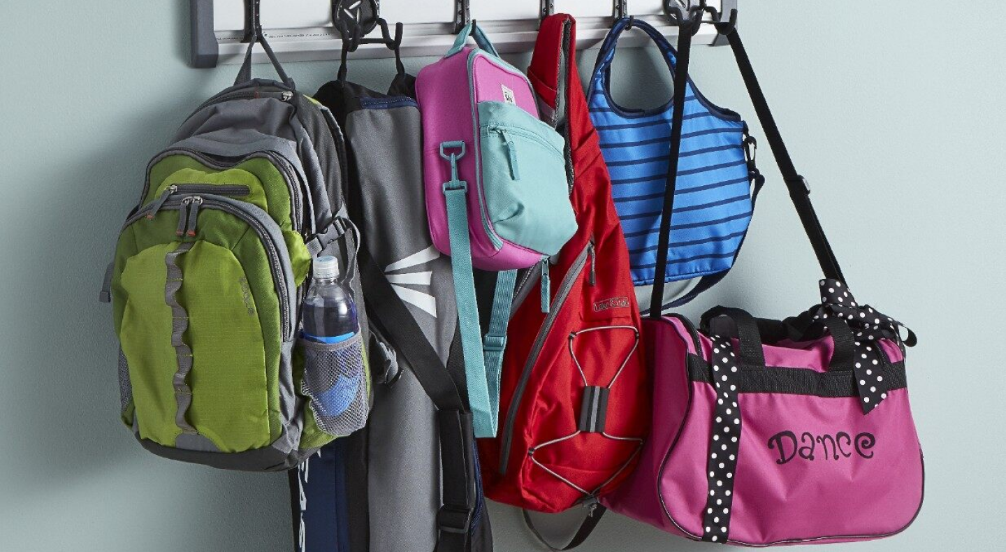 A closeup of a coat rack bags and backpacks. A closeup of a coat rack bags and backpacks.