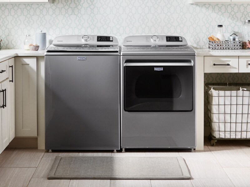 Stainless Maytag® top load washer and front load dryer side by side in a tidy, bright laundry room Stainless Maytag® top load washer and front load dryer side by side in a tidy, bright laundry room