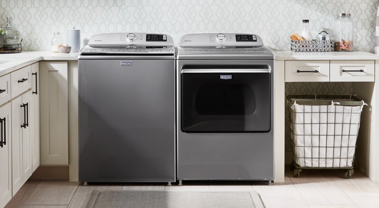 Stainless Maytag® top load washer and front load dryer side by side in a tidy, bright laundry room Stainless Maytag® top load washer and front load dryer side by side in a tidy, bright laundry room