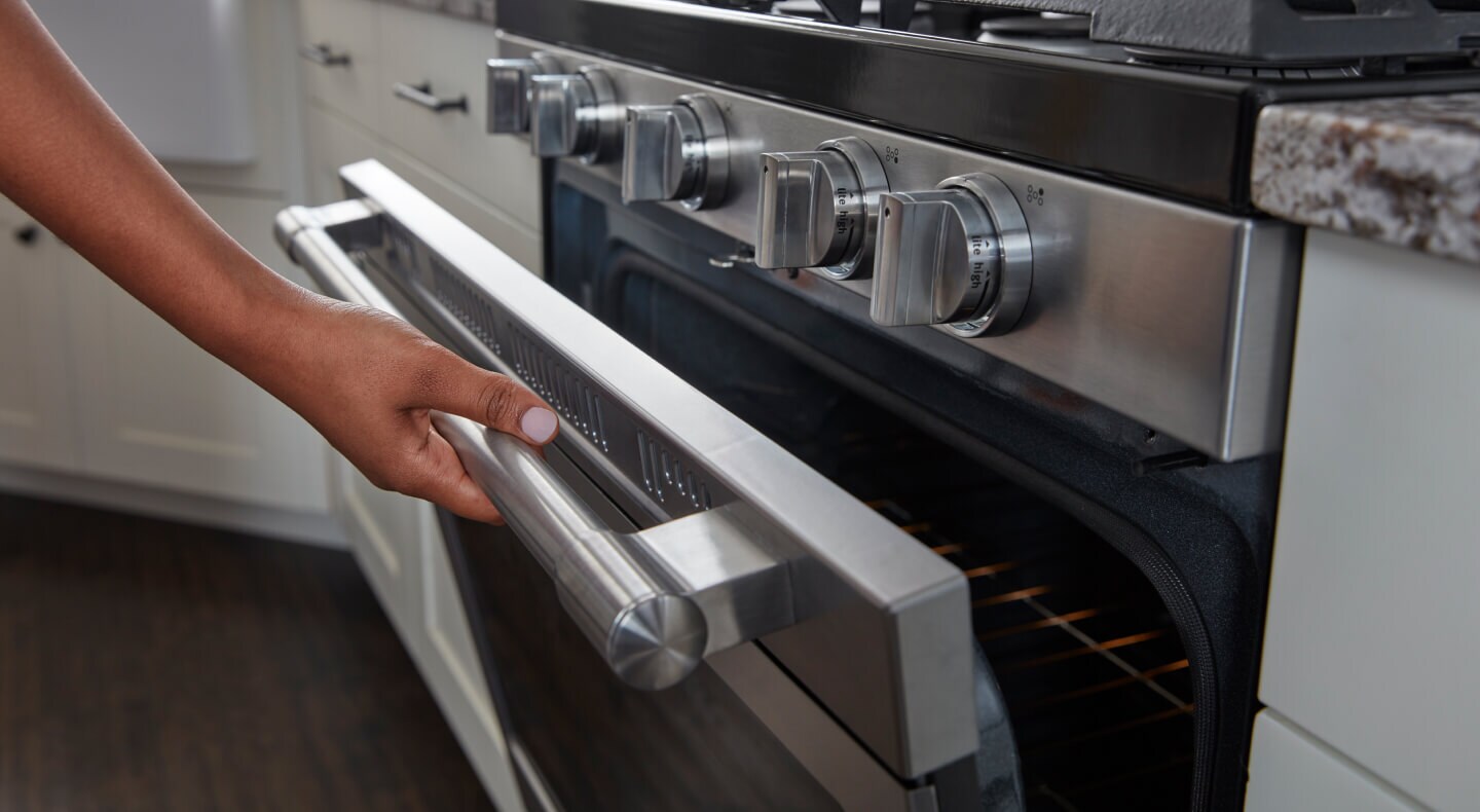 Person opening a Maytag® oven door