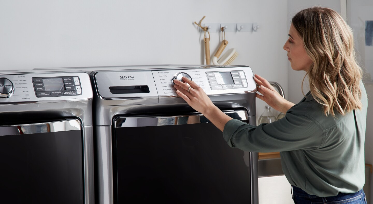 Person selecting a cycle on a Maytag® dryer