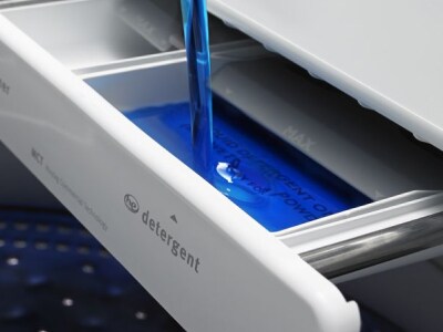 Detergent being poured into the HE slot in washing machine