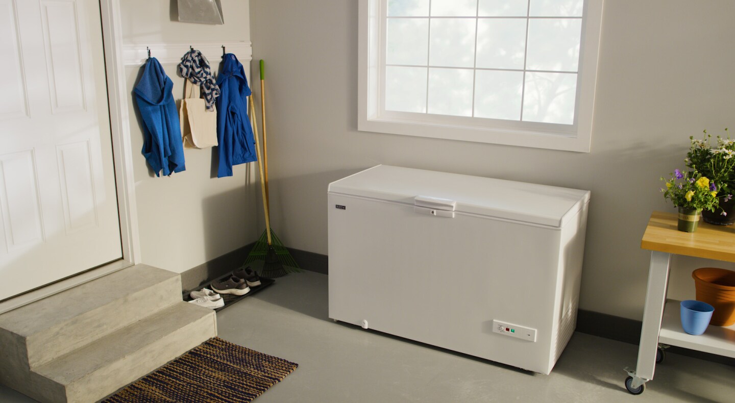 White Maytag® chest freezer in garage beneath window