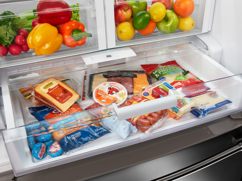 An open deli drawer of a Maytag® refrigerator with fresh food. An open deli drawer of a Maytag® refrigerator with fresh food.