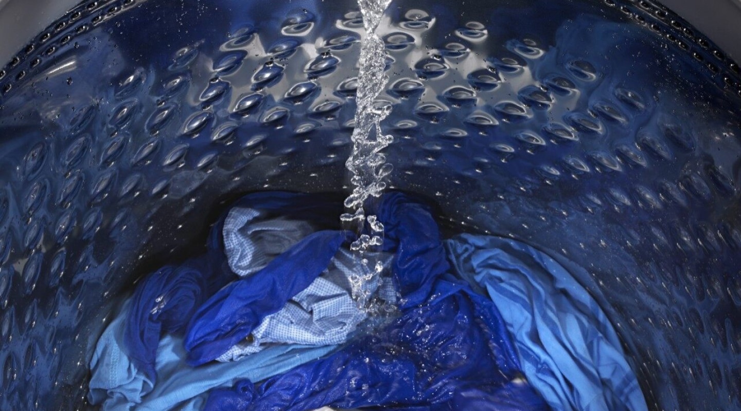 Clothes in a washing machine drum filling up with water Clothes in a washing machine drum filling up with water