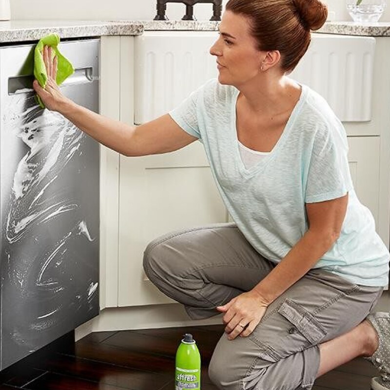Person cleaning stainless steel dishwasher with affresh® cleaner