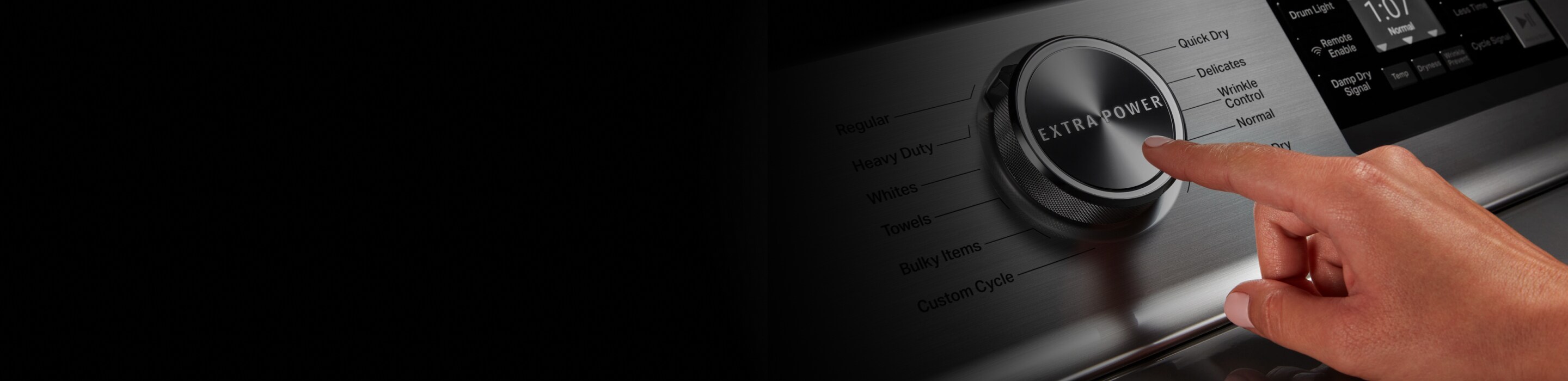 A person adjusting controls on a stainless steel dryer