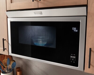 Maytag® built-in microwave surrounded by light-colored cabinets