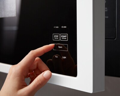 Person selecting a setting on a Maytag® microwave