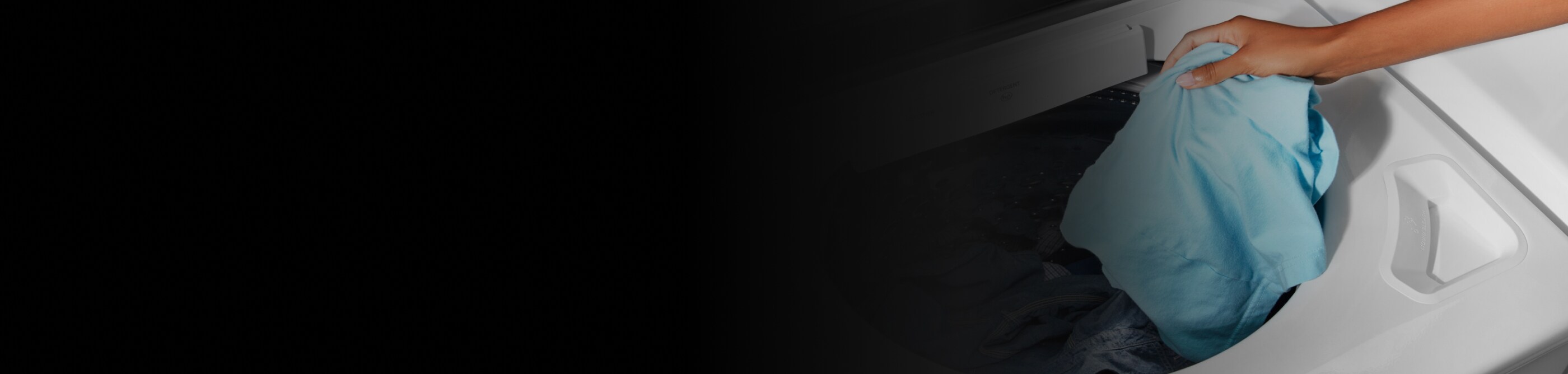 A person placing a laundry item into a washing machine