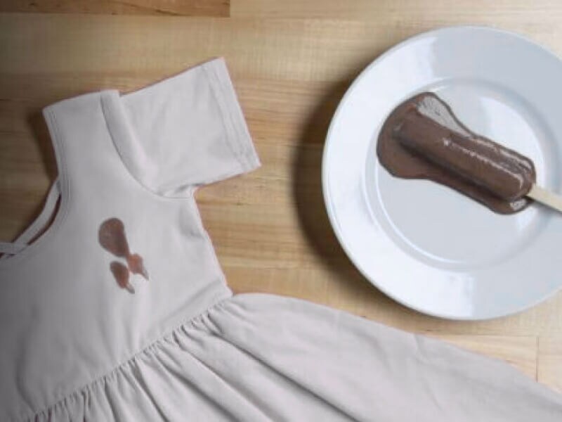 Chocolate popsicle next to a dress with a brown popsicle stain