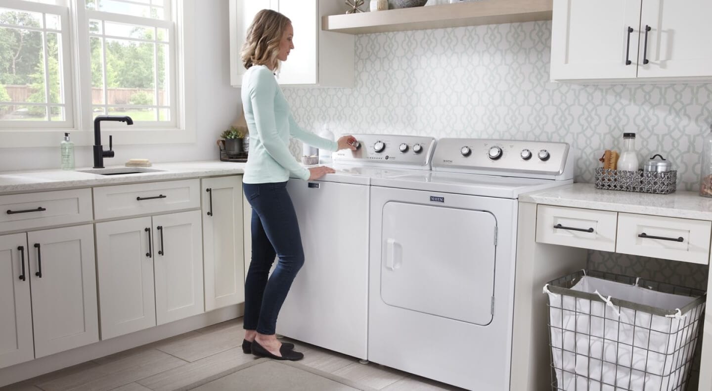 Person adjusting controls on a Maytag® top-load washer