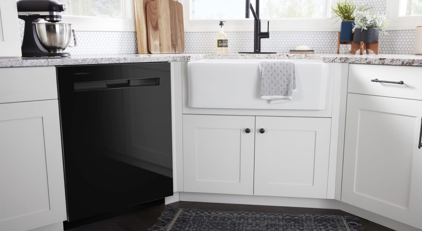 A black Maytag® dishwasher surrounded by white cabinetry A black Maytag® dishwasher surrounded by white cabinetry