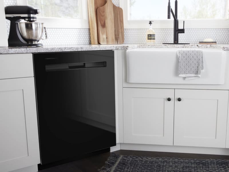 A black Maytag® dishwasher surrounded by white cabinetry A black Maytag® dishwasher surrounded by white cabinetry