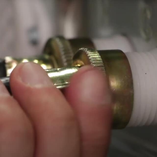 A water inlet hose being detached from a washer