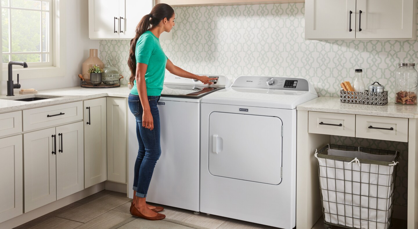 A woman selecting an option on her Maytag® washing machine. A woman selecting an option on her Maytag® washing machine.