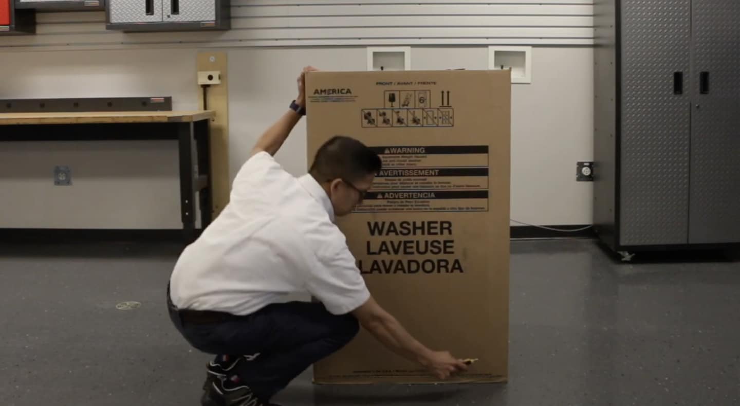 A man unpacking a Maytag® top load washing machine. A man unpacking a Maytag® top load washing machine.