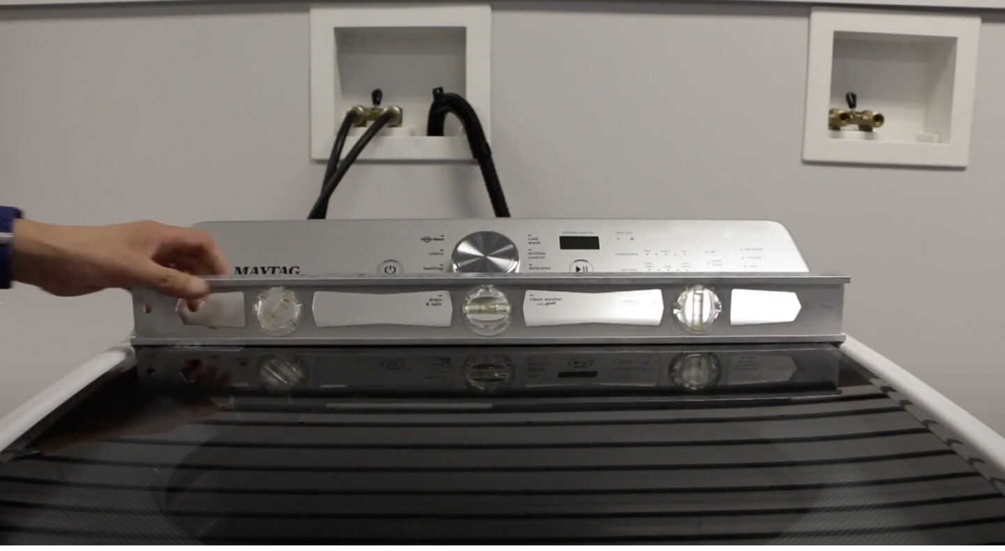 A man checking the levelness of a Maytag® washing machine. A man checking the levelness of a Maytag® washing machine.