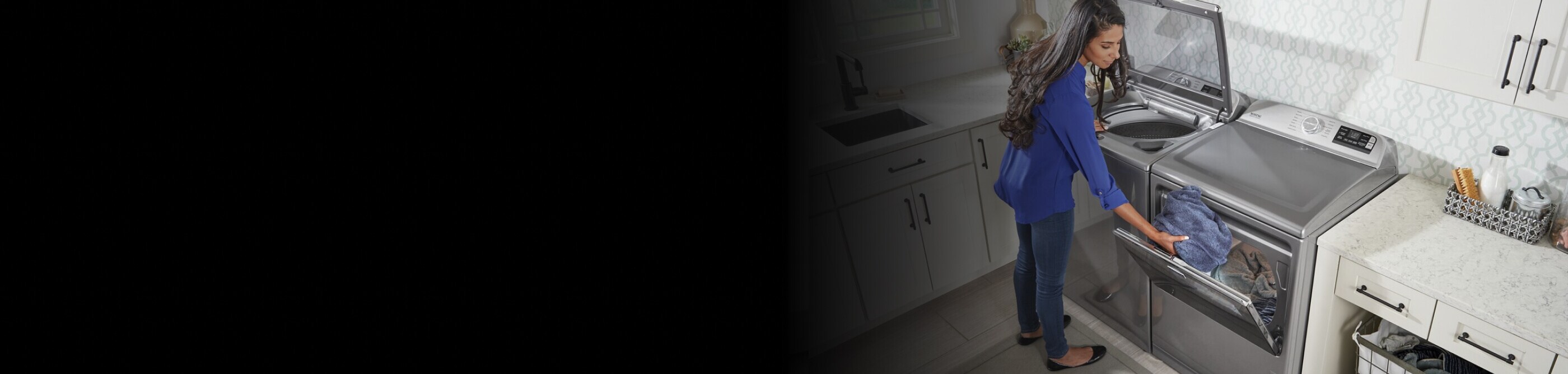 A person switching clothes between a washer and a dryer