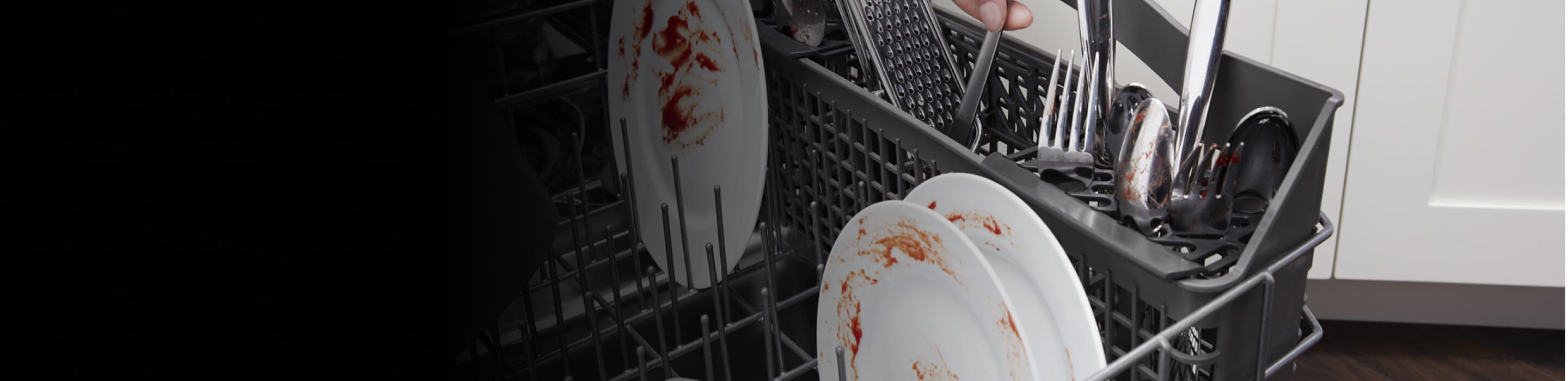 Hand loading silverware into a dishwasher
