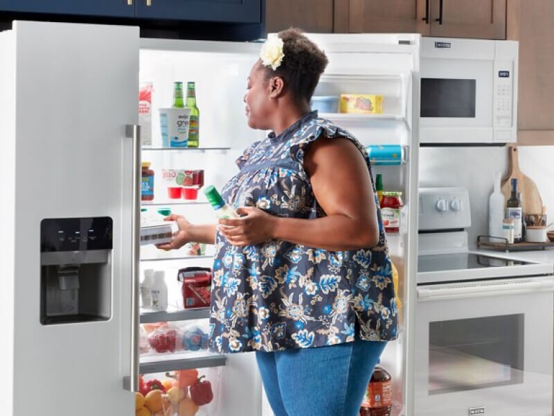 Person placing food inside a refrigerator