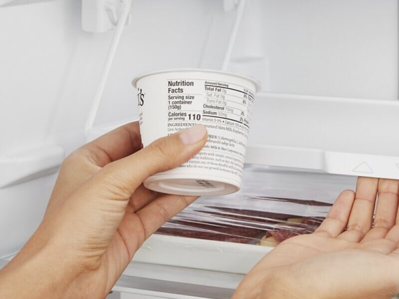 Person holding a cup of yogurt