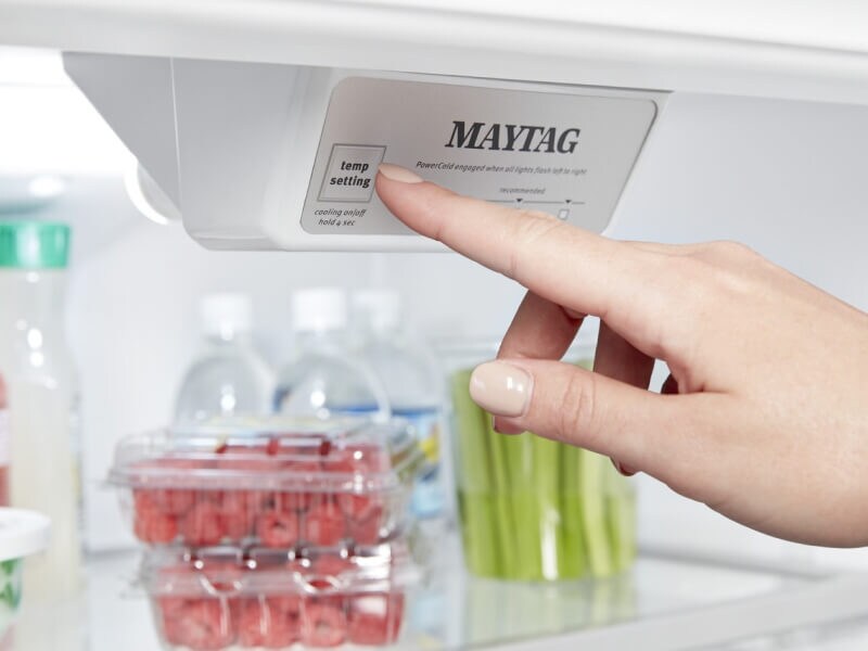 Person selecting a setting on a Maytag® refrigerator