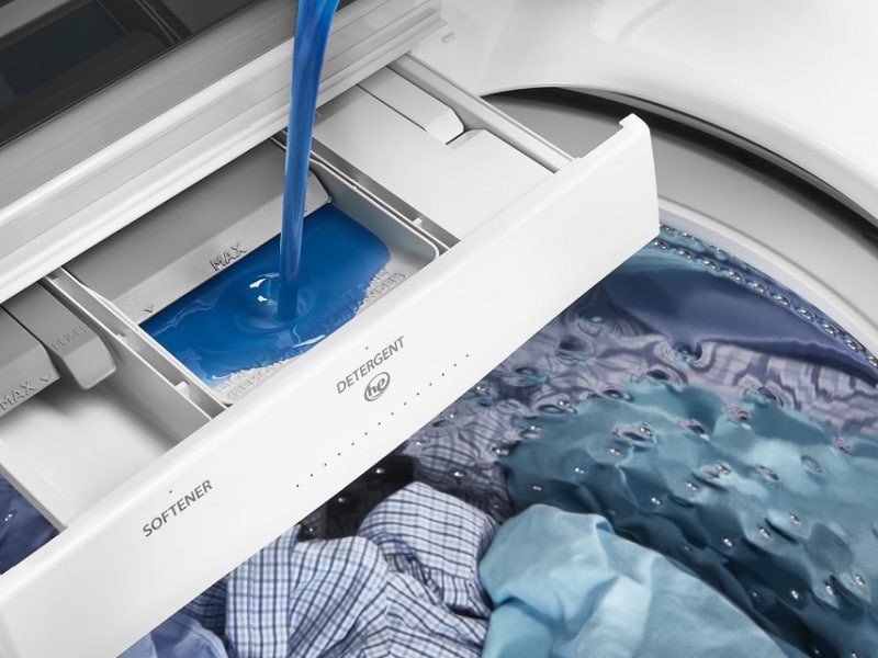 Detergent being poured into a washer detergent dispenser Detergent being poured into a washer detergent dispenser