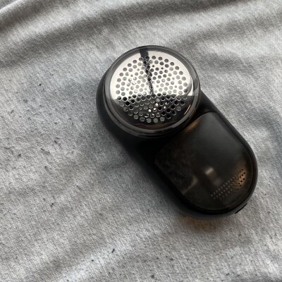 A fabric shaver on a pair sweatpants with fabric pilling