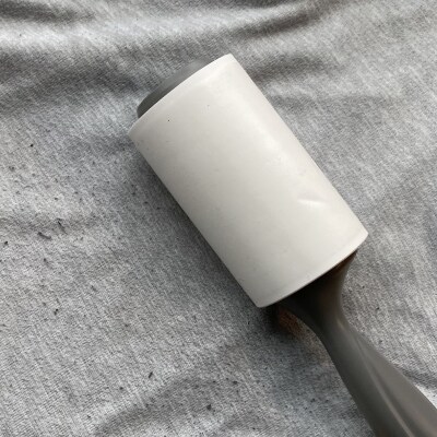 A lint roller on a pair of sweatpants with pilling