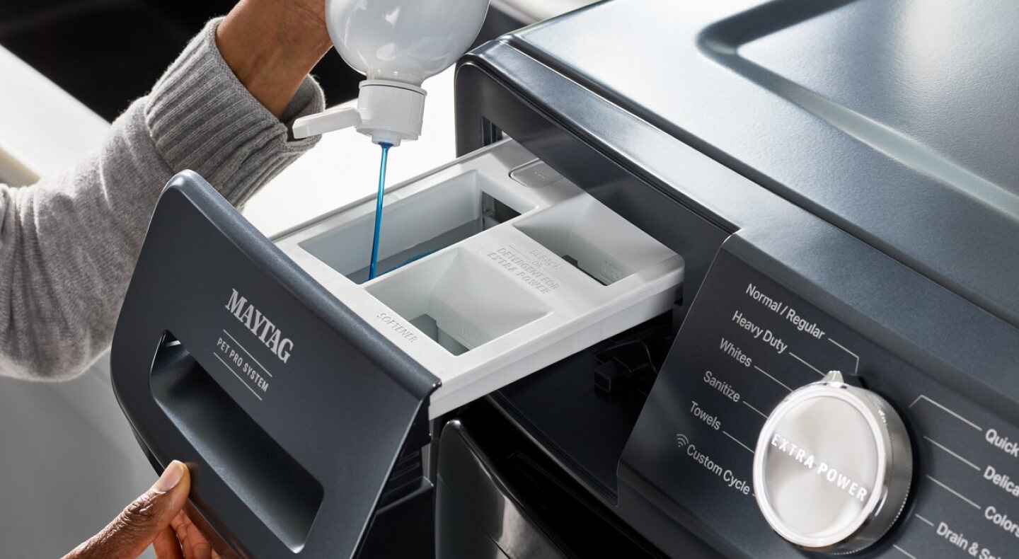 A person pouring detergent into a Maytag® washer