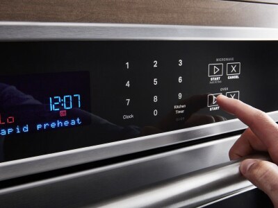 Hand pressing preheat on the oven console