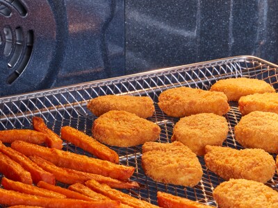 Sweet potato fries and chicken nuggets in an air fry basket