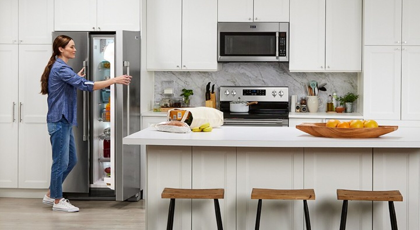 A person opening a refrigerator in a modern kitchen