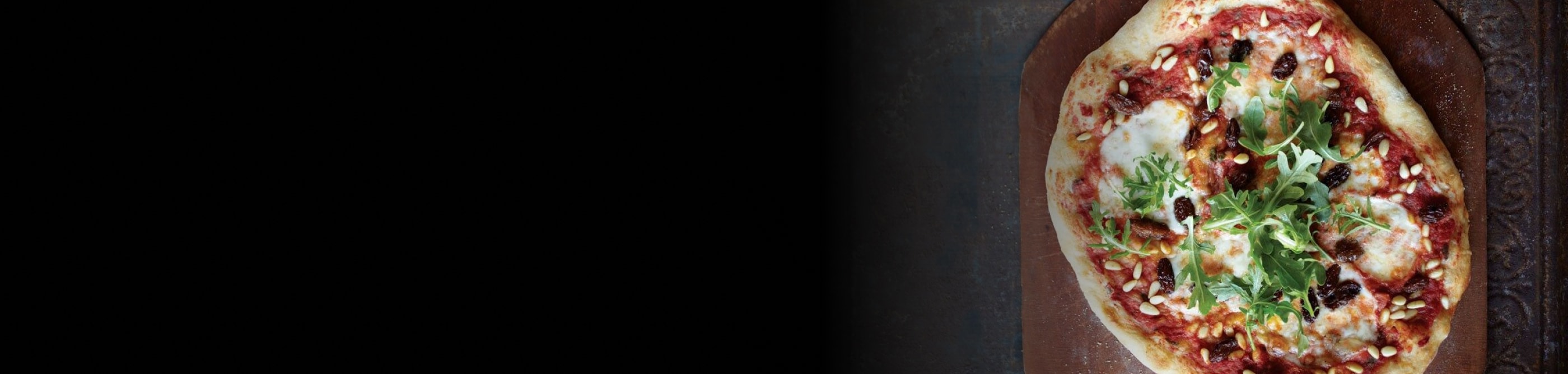 A homemade pizza with raisins and parsley on top