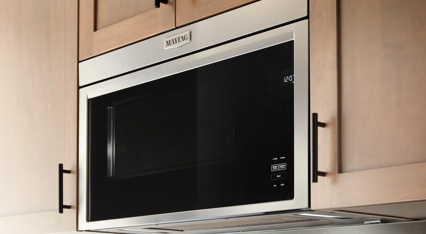 A Maytag brand microwave set into wooden cabinetry