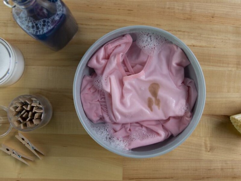 Stained pink blouse soaking in a bowl with cleaning products Stained pink blouse soaking in a bowl with cleaning products