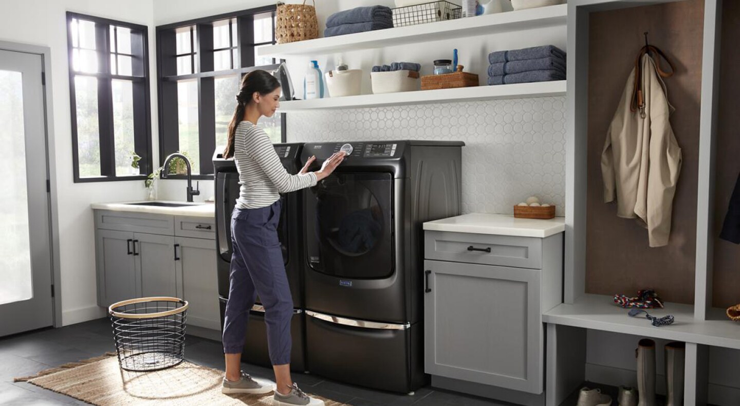 Person admiring the control panel on a large black washing machine. 