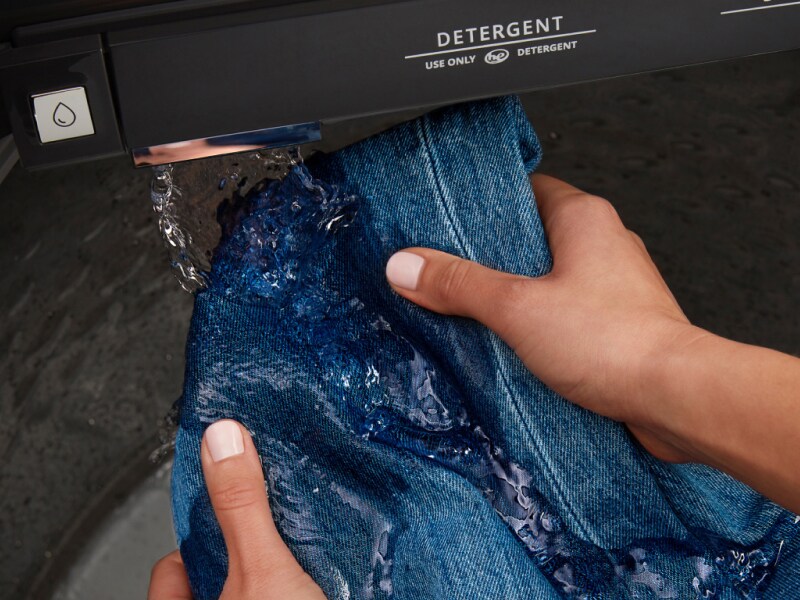 Person rinsing jeans in a Maytag® washer Person rinsing jeans in a Maytag® washer