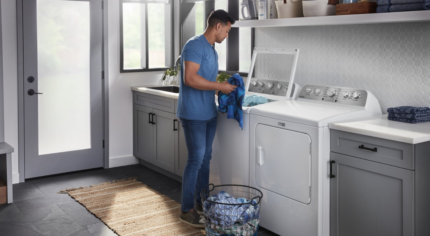 Person putting clothing in washing machine