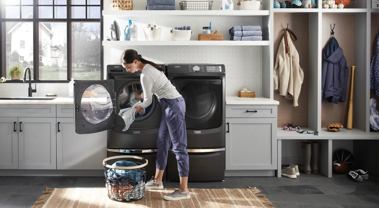 Person loading laundry into a front loading washer