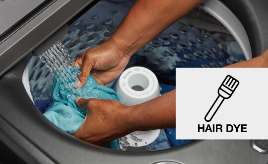 Person pre-treating a stain in a washing machine with a built-in faucet