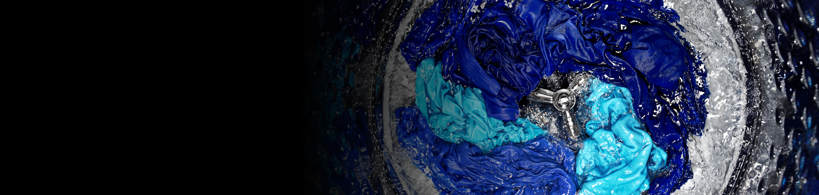 Assorted blue clothes agitating in the washer